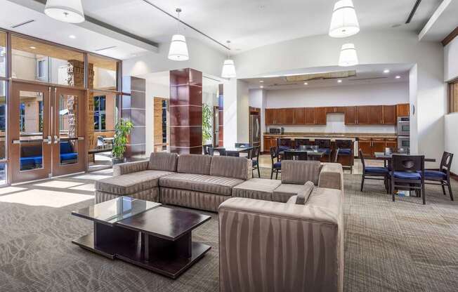 A modern living room with a grey carpet and a coffee table in the center.