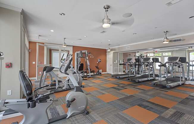 a gym with treadmills and other exercise equipment at the enclave at university heights