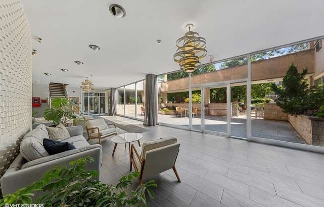 a living room with a couch and chairs in front of a large window