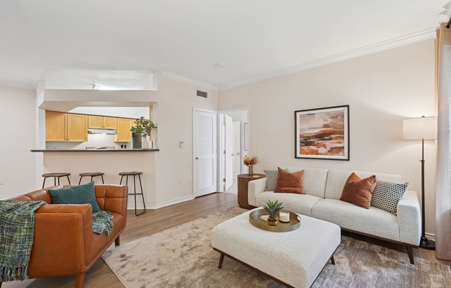 A living room with a white couch, a brown armchair, and a coffee table.
