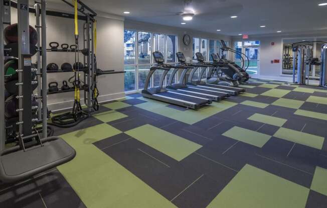 A gym with treadmills, weights, and exercise equipment.