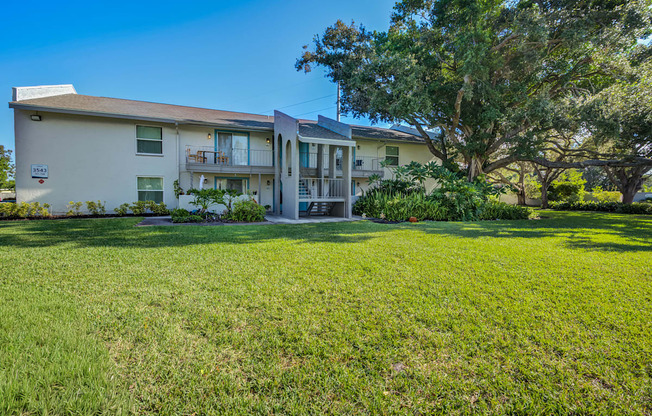 A two-story apartment building with a green lawn in front.