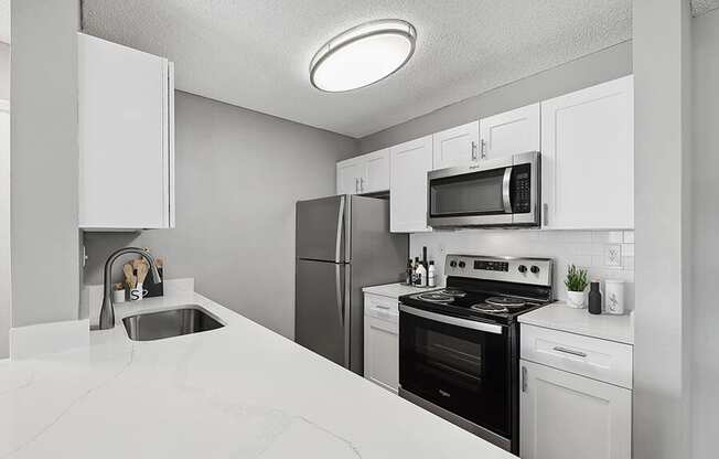 Model Kitchen with White Cabinets and White Marble Countertops at Fountains Lee Vista Apartments in Orlando, FL.