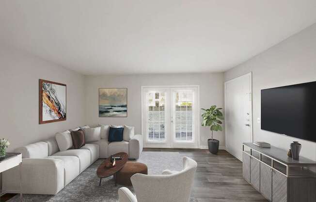 A living room with a white couch, a brown coffee table, and a painting on the wall.