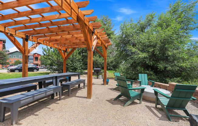 a picnic area with benches and tables and a pergola at Switchback on Platte Apartments, Colorado