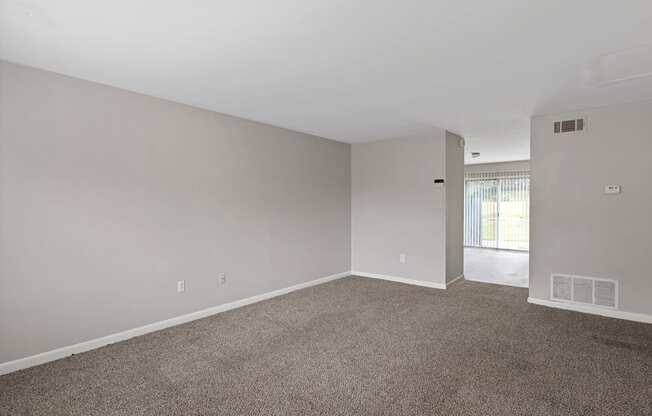 an empty living room with carpet and white walls