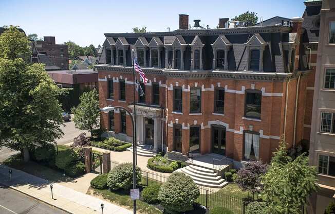 an aerial view of a red brick building with an flag at The Knights @ 506 Delaware Apartments, Buffalo, NY