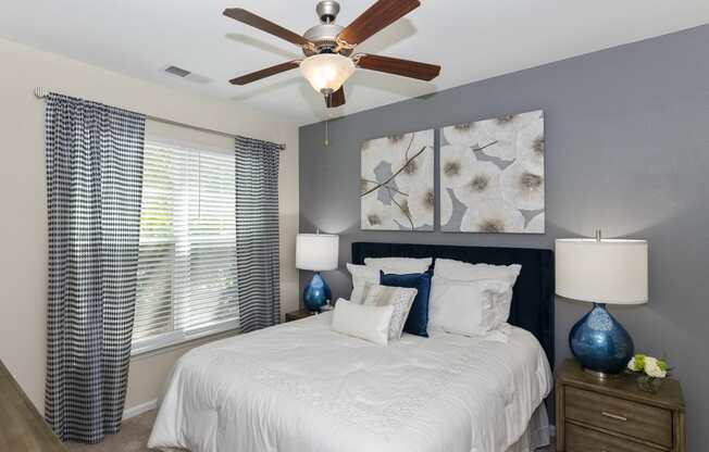 a bedroom with a large white bed and a ceiling fan