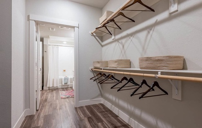 a laundry room with baskets on a rack and a door to a bathroom