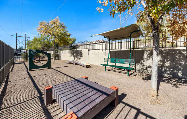 A playground with a slide, swings, and a seesaw.