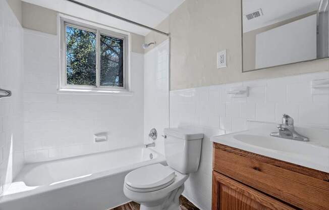 A white toilet sits next to a white sink in a bathroom at Highland Ridge Apartments, Maryland