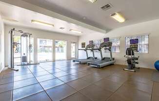 A gym with treadmills, elliptical machines, and a ball.