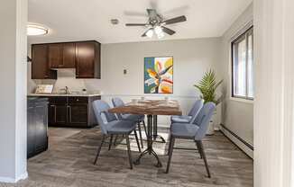 an open kitchen and dining room with a table and chairs and a ceiling fan