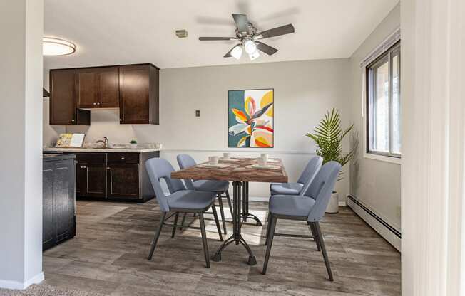 an open kitchen and dining room with a table and chairs and a ceiling fan