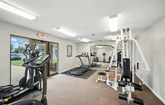 A gym with treadmills, weights, and exercise equipment at Arbors at Georgetown Apartments, Lansing, MI, 48911