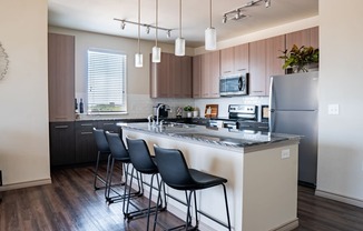 a kitchen with a large center island with a breakfast bar