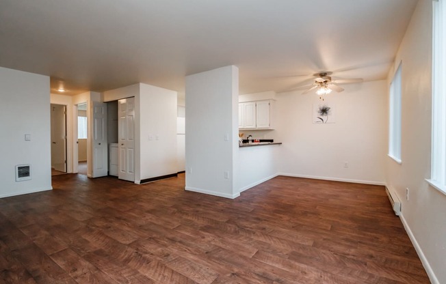 an empty living room with a ceiling fan