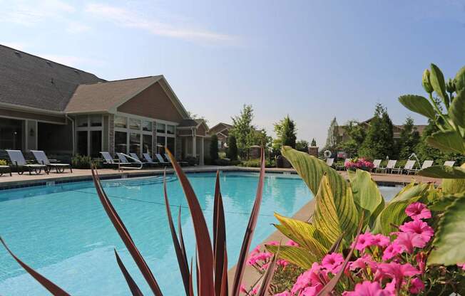 a swimming pool with pink flowers in front of a house at Sovereign at Overland Park, Overland Park, 66213  