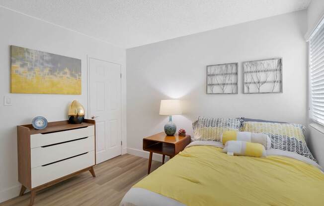 A bedroom with a bed, nightstand, and lamp at Verandas Apartments, West Covina, 91791