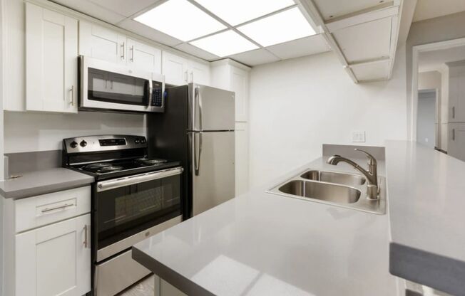 a kitchen with white cabinets and a sink and a refrigerator