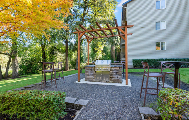 BBQ area with greenery and an apartment building in the background