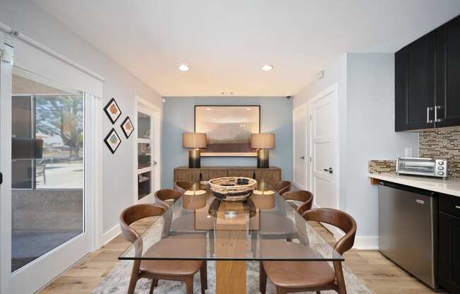 a dining room with a glass table and chairs