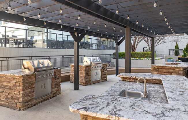 A patio with a stone counter and a sink.