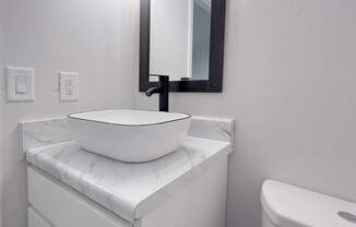 Retreat at Indian Lake apartments in Hendersonville, TN white bathroom vanity with a marble top and a mirror above it.