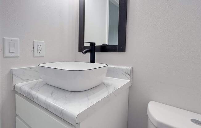 Retreat at Indian Lake apartments in Hendersonville, TN white bathroom vanity with a marble top and a mirror above it.