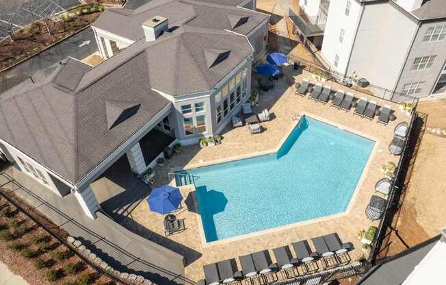 an aerial view of a large swimming pool in front of a house