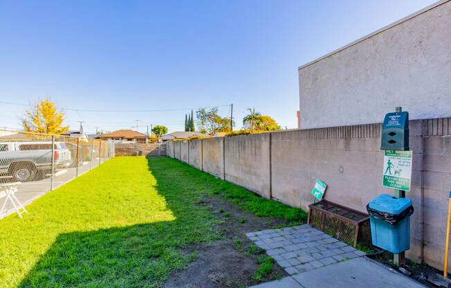 a yard with a fence and a green lawn next to a parking meter