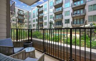 a balcony with a view of an apartment building and a pool at Link Apartments® 4th Street, Winston-Salem, NC, 27101