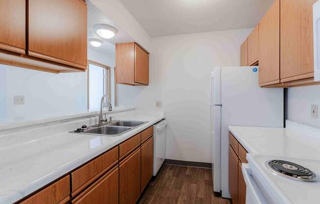 A kitchen with white appliances and wooden cabinets.
