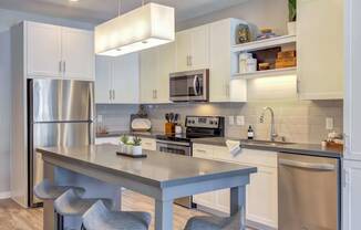 Modern kitchen with bright white cabinetry, stainless steel appliances, and custom kitchen islands.