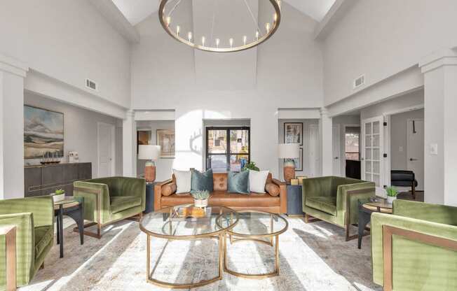 A living room with a glass coffee table and green chairs.