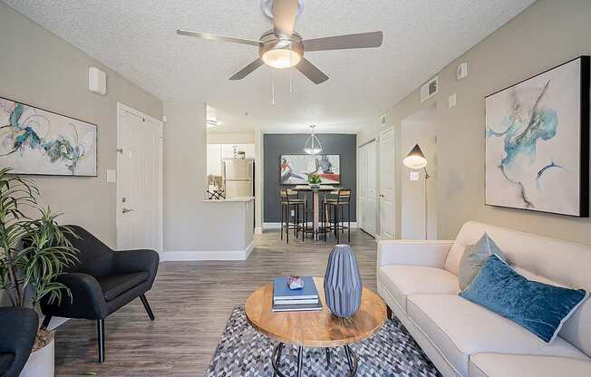 A living room with a black chair, a white couch, and a wooden coffee table at Sterling Point Apartment Homes, Phoenix, AZ, 85042