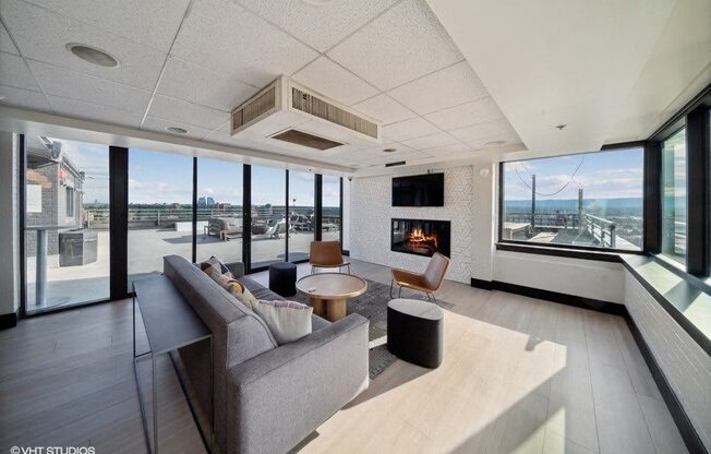 A modern living room with a grey sofa and a fireplace at Archer Tower in Denver, CO