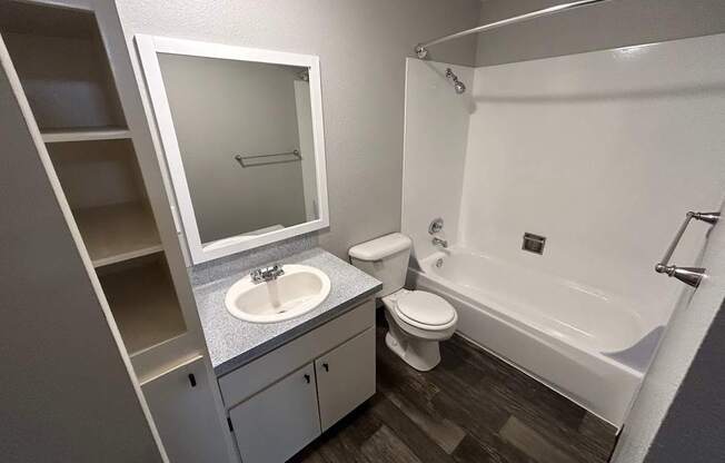 A white bathroom with a toilet, sink, and bathtub.