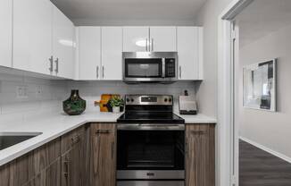 a kitchen with white cabinets and a black stove top oven