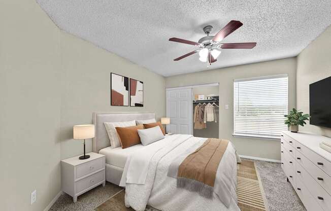 A bedroom with a bed, nightstand, and a ceiling fan.