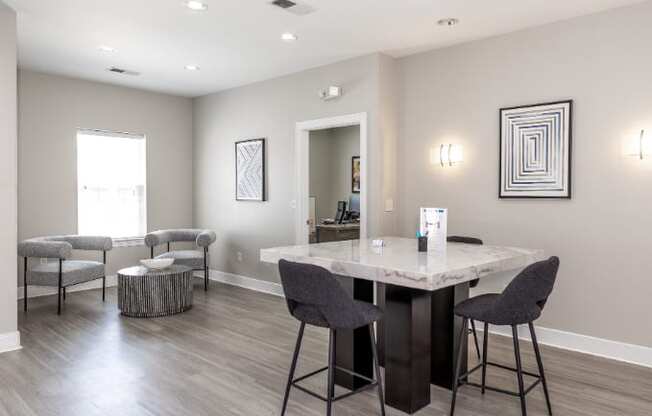 A dining room with a marble table and grey chairs.
