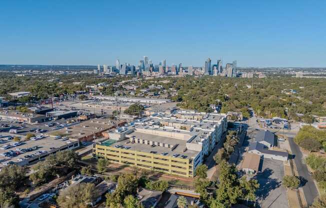 an aerial view of a building with a city skyline in the background