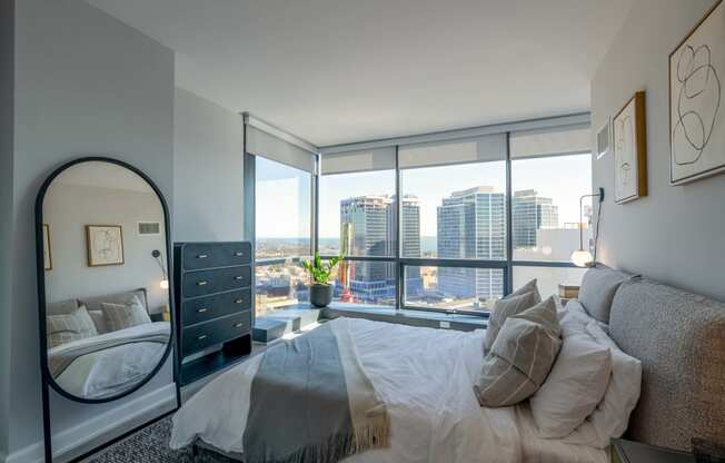 a bedroom with a large bed and a view of the city