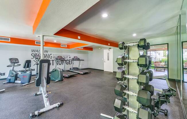 a spacious fitness center with weights and other exercise equipment