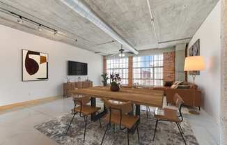 A dining room with a long wooden table and chairs.