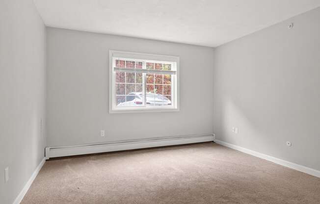 Empty bedroom with a window and carpet  at the River, Manchester, 03102