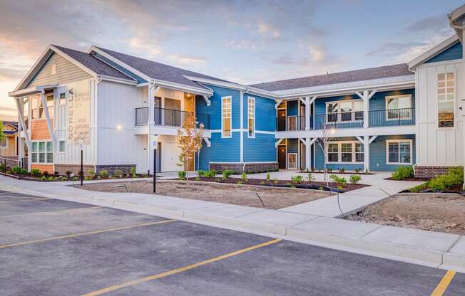 a row of blue and white townhomes with a sidewalk in front of them