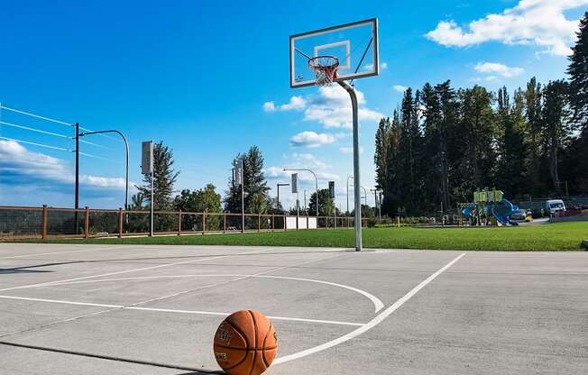 A basketball is on the ground in front of a basketball hoop.