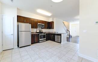 kitchen with espresso cabinetry, view of dining area and stainless steel appliances at sheridan station south townhomes in washington dc