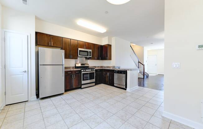 kitchen with espresso cabinetry, view of dining area and stainless steel appliances at sheridan station south townhomes in washington dc